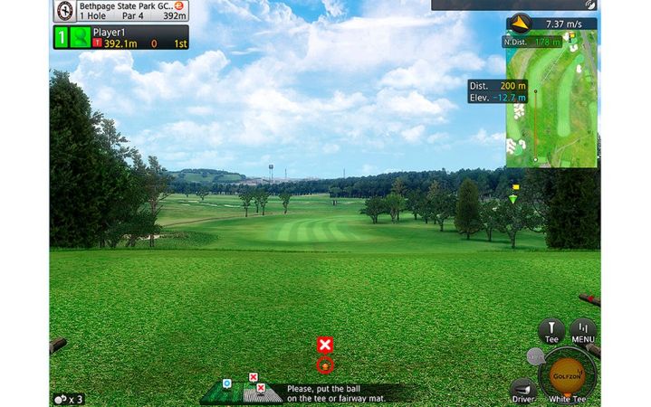 Golfer reviewing shot data on a golf simulator screen at home