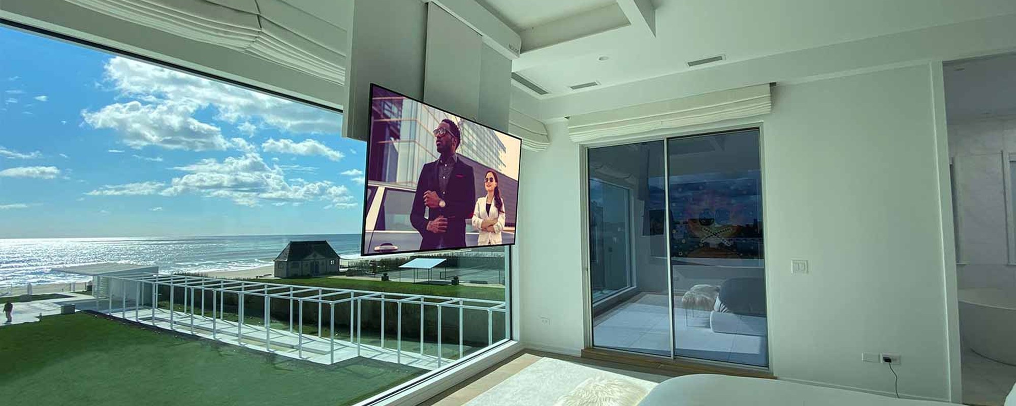 Nexus 21 CL-65e flip-down ceiling TV lift lowered in a bedroom