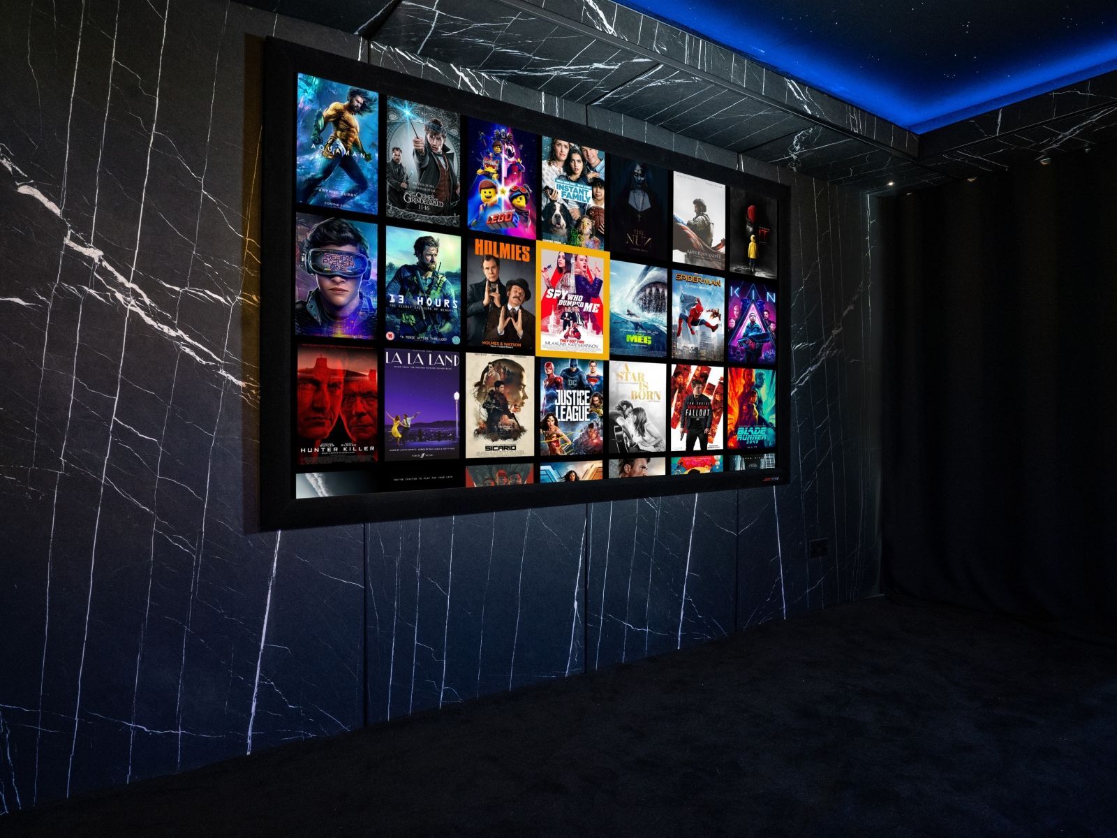 Dark marble-look home cinema wall with large screen and Vicoustic acoustic treatment