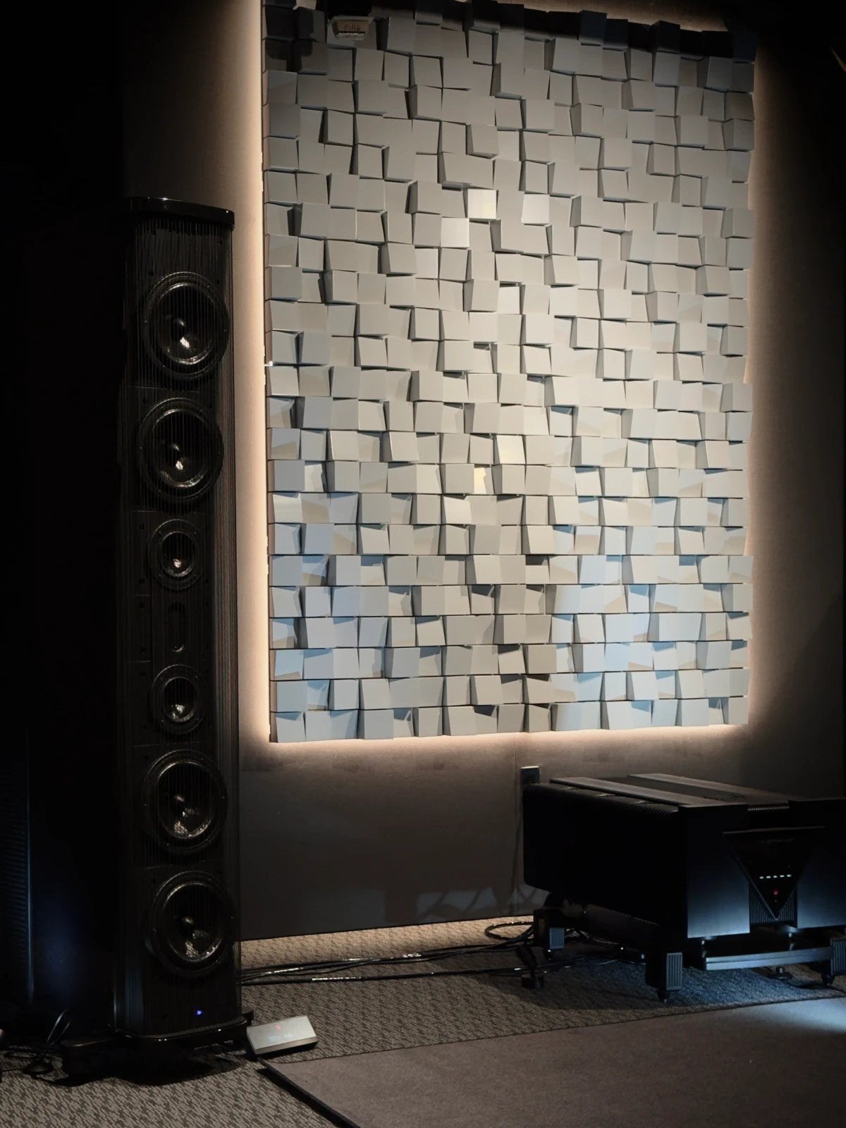 Vicoustic diffuser wall behind tall floor-standing speakers