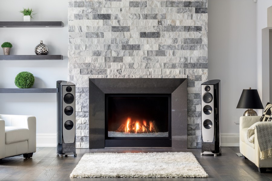 Paradigm’s Persona 3F loudspeakers in a living room on either side of a lit fireplace.